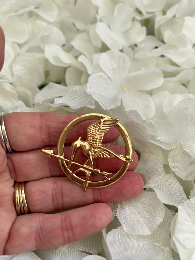 Hunger Games metal mockingjay/ mockingbird & arrow pin badge brooch presented in an organza gift bag Copper