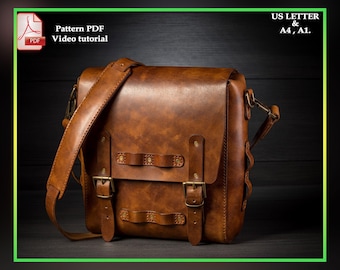 May include: A brown leather messenger bag with a flap closure, two buckles, and a long adjustable strap. The bag has a distressed look and is made of high-quality leather.