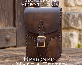 May include: A dark brown leather pouch with a flap closure, secured by a brass-colored metal buckle. The pouch features visible stitching along the edges and two belt loops on the top. Text reads: DIGITAL PATTERN PDF DXF SVG VIDEO TUTORIAL DESIGNED, MADE & TESTED by a leatherworker.