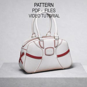 May include: White handbag with red accents and stitching. Features a top zipper, dual handles, and a decorative red 'X' on the side. The text "PATTERN PDF - FILES VIDEO TUTORIAL" is visible at the top.