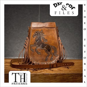 May include: Brown leather shoulder bag with a fringe trim and an embroidered horse design. The bag has a strap and a metal buckle. The bag is on a wooden surface. DXF & PDF FILES.