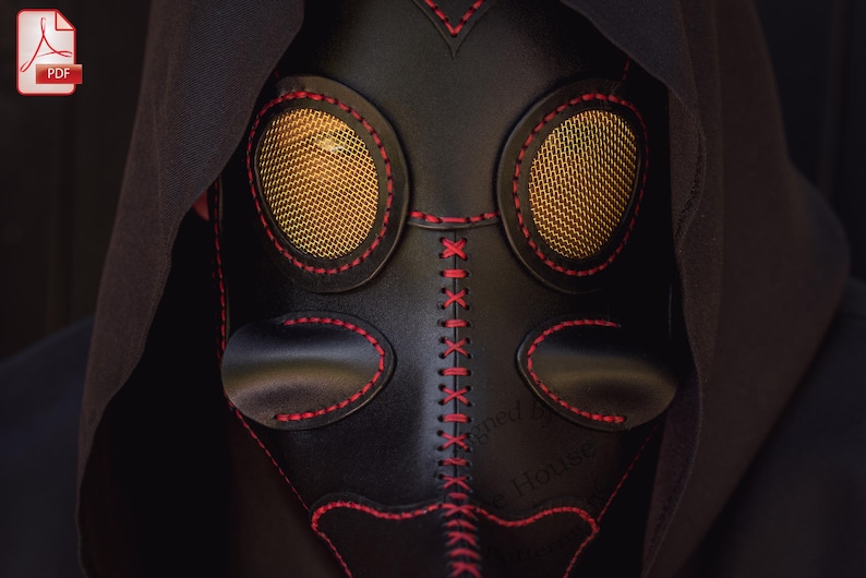 May include: A black leather mask with red stitching and gold mesh eye coverings. The mask has a long nose and a stitched design on the front.