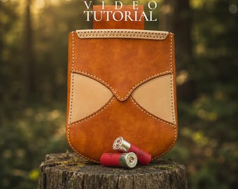 May include: A handcrafted leather cartridge bag in shades of brown and tan, with decorative stitching. Two red shotgun shells rest in front of the bag. The text "PATTERN SVG-DXF-PDF VIDEO TUTORIAL" is at the top.