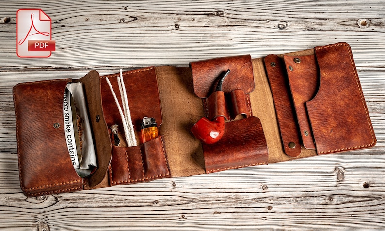 May include: A brown leather tobacco pouch with multiple compartments. The pouch is open and shows a pack of tobacco, a lighter, pipe cleaners, and a pipe.