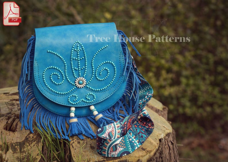 Op de afbeelding: Een blauwe leren schoudertas met franjes en een parelmoerontwerp. De tas heeft een paisley-patroonband en de tekst "Tree House Patterns" is zichtbaar op de tas.