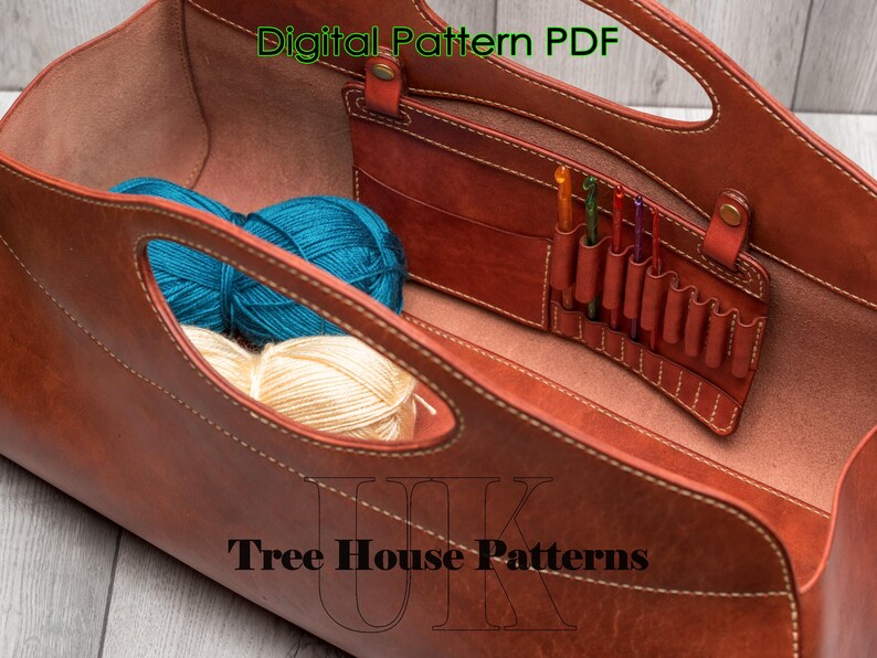 May include: A brown leather tote bag with a zipped pocket and a label that says "Digital Pattern PDF" and "Tree House Patterns". The bag is open and contains yarn and knitting needles.