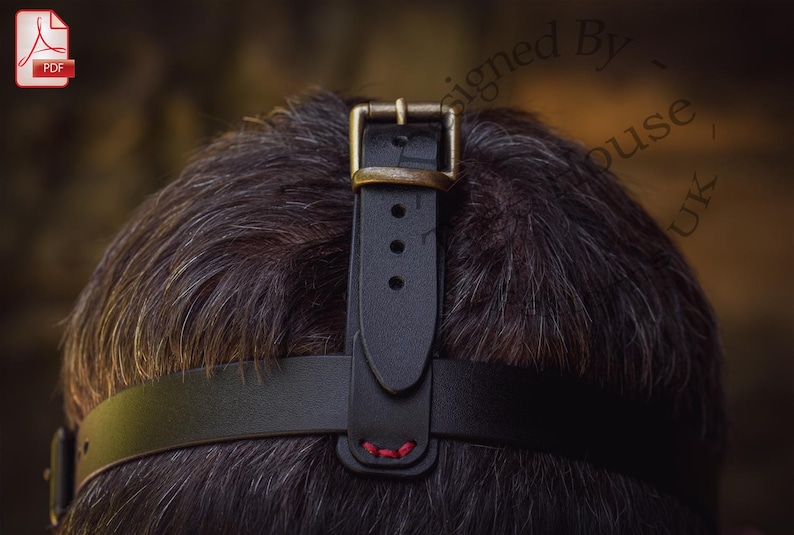 May include: Black leather headband with a brass buckle and red stitching. The headband is adjustable and can be worn on the head or forehead.