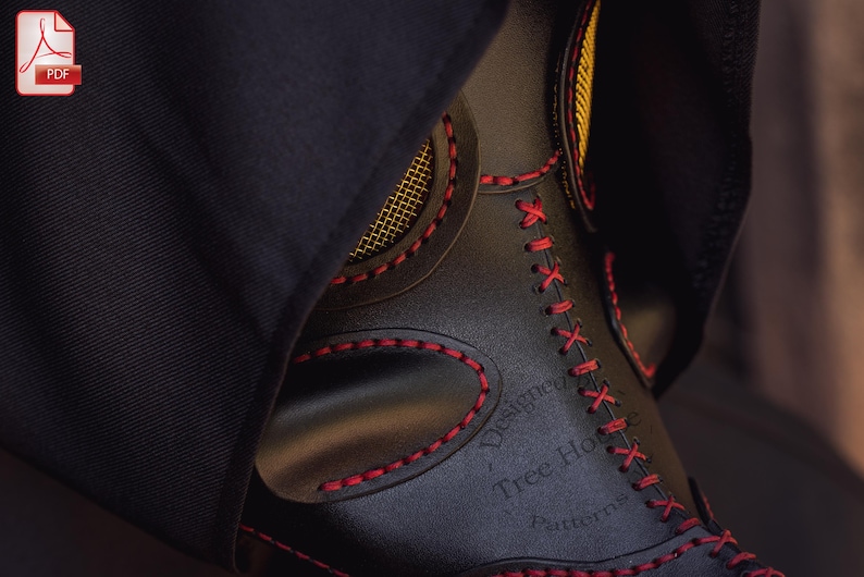 May include: Close-up of a black leather mask with red stitching. The mask has a mesh nose piece and the text "Designed by Tree House Automata" is visible.