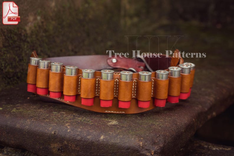 May include: A brown leather shotgun shell belt with 12 shotgun shells. The belt has a red and white stitching detail. The text 'Tree House Patterns' is visible on the belt.