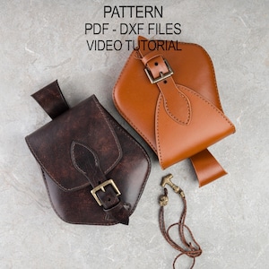 Puede incluir: Dos bolsas de cuero en tonos marrón y beige, con cierres de hebilla y costuras decorativas. También hay un pequeño colgante de color bronce con un cordón de cuero trenzado. El texto "PATTERN PDF - DXF FILES VIDEO TUTORIAL" es visible en la parte superior.