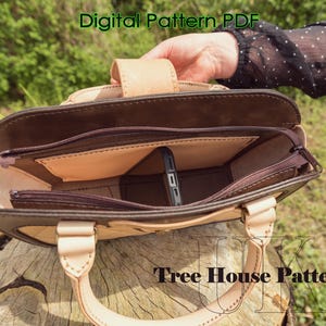 May include: A brown leather handbag with a zippered top and a beige leather handle. The bag has a beige leather interior with a pocket for a phone. The bag is open and the interior is visible. The text "Tree House Patterns" is visible on the bottom of the image.