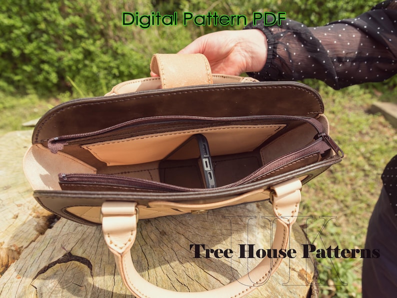 May include: A brown leather handbag with a zippered top and a beige leather handle. The bag has a beige leather interior with a pocket for a phone. The bag is open and the interior is visible. The text "Tree House Patterns" is visible on the bottom of the image.