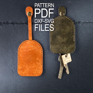 May include: Two leather key fobs, one orange and one olive green, with keys attached. The orange fob is on the left, and the green fob is on the right. The text "PATTERN PDF DXF-SVG FILES" is in white on the top.