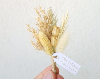 Op de afbeelding: Een boeket gedroogde bloemen met een wit label waarop staat "Patrick & Lizzie September 2nd, 2023".