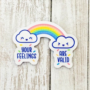 May include: Two white clouds with happy faces, one saying "Your Feelings" and the other saying "Are Valid", are connected by a rainbow with a light blue background. The clouds and rainbow are on a white background with confetti.