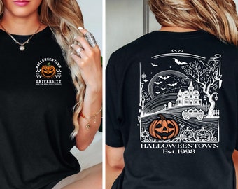 May include: Black t-shirt with a white graphic on the front that says "Halloweentown University" and a small orange pumpkin. The back of the shirt has a white graphic of a spooky house, trees, bats, and a moon with the text "Halloweentown Est 1998".