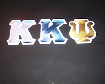 Könnte beinhalten: Drei große griechische Buchstaben, Kappa, Kappa und Psi, horizontal angeordnet. Die ersten beiden Buchstaben haben eine metallisch schimmernde blaue Oberfläche, während der dritte Buchstabe eine metallisch goldene Oberfläche aufweist. Jeder Buchstabe hat einen dicken weißen Rand.