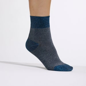 May include: A pair of ankle socks with a gray base and a blue glitter band around the top and heel.