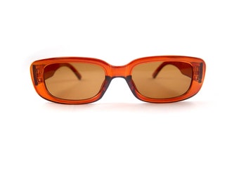 May include: Orange tinted rectangular sunglasses with a brown frame.