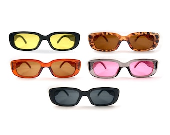 May include: Five pairs of rectangular sunglasses with different colored lenses. The sunglasses have black, brown, gray, and orange frames.