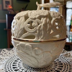 May include: A white ceramic mug with a black handle and the text "But First, Coffee" in a black, bold font. The mug is on a white surface. The mug is 4 inches tall.