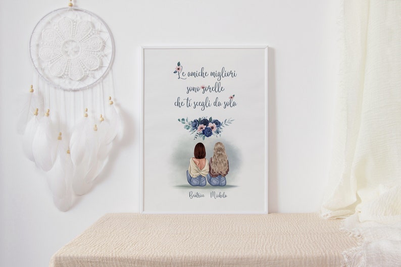 May include: A framed art print featuring an illustration of two women sitting together, with the text "Le amiche migliori sono sorelle che ti scegli da sola" and the names Beatrice Michela. The artwork has a floral design.