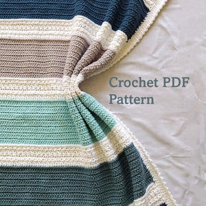 May include: A crocheted blanket with horizontal stripes in shades of blue, white, and tan. The blanket has a scalloped white border and the text "Crochet PDF Pattern".