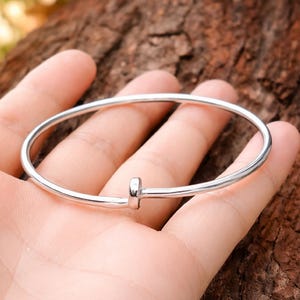 Può includere: Un set di tre tazze in ceramica con finitura opaca e macchiettata. Le tazze sono nei toni del crema, grigio chiaro e grigio scuro. Ogni tazza ha un design semplice e minimalista e un manico arrotondato.