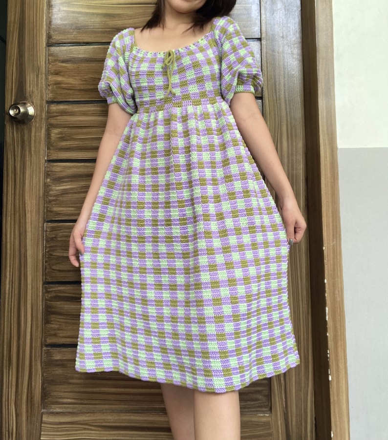 May include: A green and purple gingham crochet dress with a square neckline and puff sleeves.