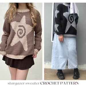 以下が含まれることがあります： 星雲のデザインが施された、2つの手編みのセーター。左側のセーターは、ベージュの星がついた茶色。右側のセーターは、灰色の星がついた黒色です。