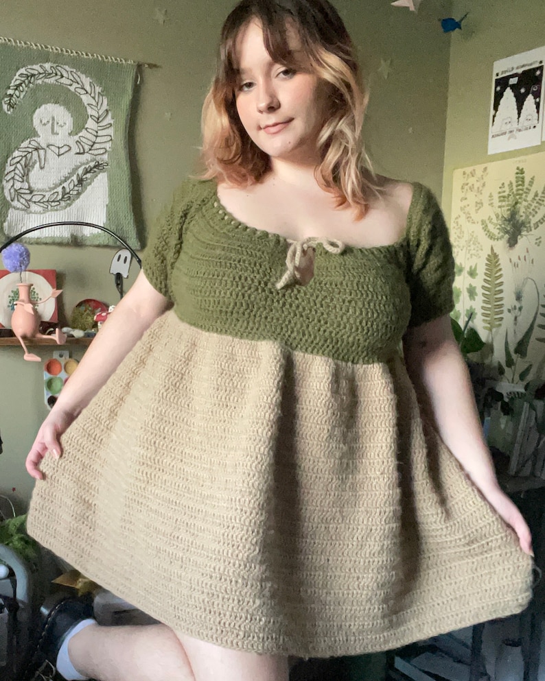May include: A green and beige crochet dress with a tie at the neckline. The dress has a fitted bodice and a flowy skirt.