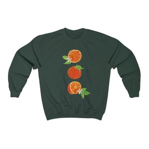 May include: A dark green sweatshirt with a graphic of three orange slices with white blossoms and green leaves.