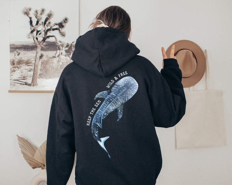 May include: Black hoodie with a whale shark graphic on the back. The graphic is blue and white and says "Keep the sea wild & free".
