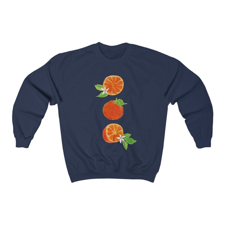 May include: Navy blue sweatshirt with a graphic of three orange slices with white blossoms and green leaves.