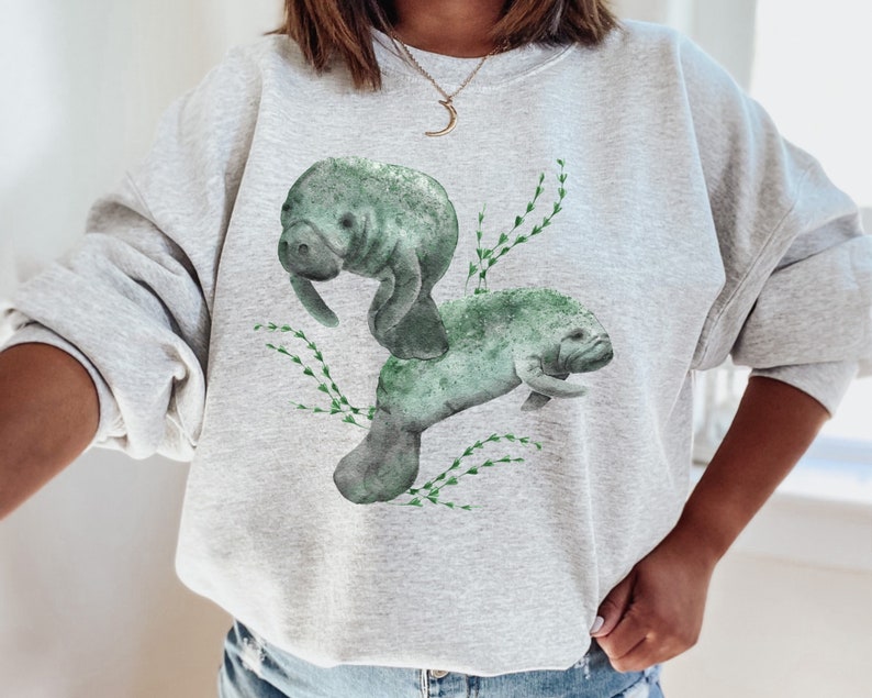 Two large watercolor manatees and seaweed on the front of a sweatshirt