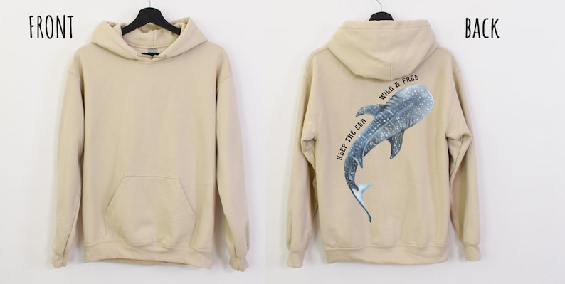 May include: A beige hoodie with a pocket on the front. The back of the hoodie features a blue and white whale shark with the text "Keep the Sea Wild & Free".
