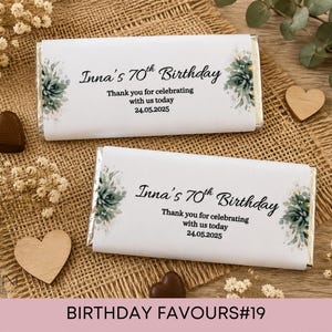 May include: Two rectangular chocolate bars wrapped in white paper with green succulent illustrations on the sides. The text reads: Inna's 70th Birthday, Thank you for celebrating with us today, 24.05.2025. The wrappers feature black script and sans-serif fonts.