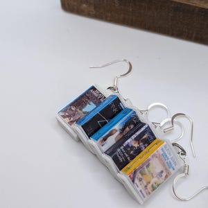 a pair of earrings with a magazine attached to them