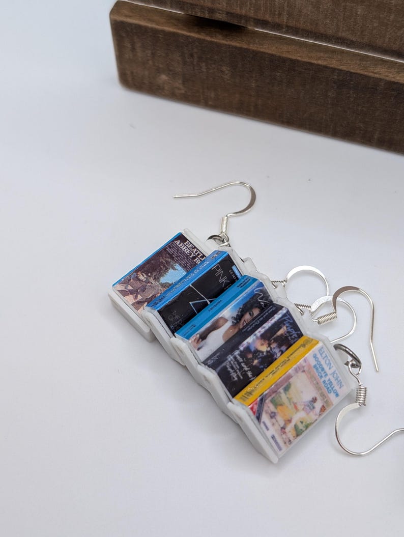 a pair of earrings with a magazine attached to them