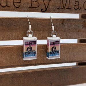 a pair of earrings hanging from a wooden bench