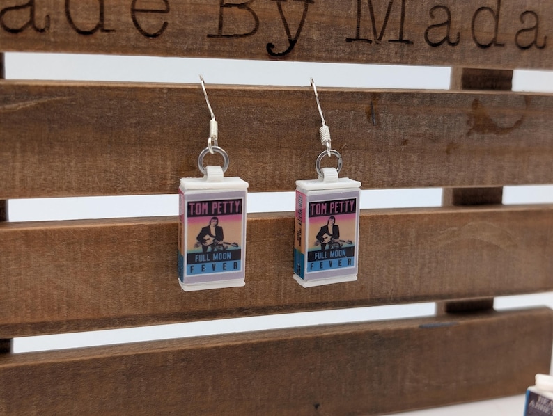 a pair of earrings hanging from a wooden bench