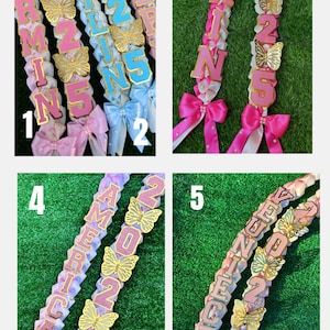 May include: A collage of five graduation leis. Each lei features a ribbon base with gold butterfly accents and the year "2025" or "2026". The leis are adorned with letters spelling out "ARIZONA", "AMERICA", and "JUNE". Each lei has a bow at the bottom.