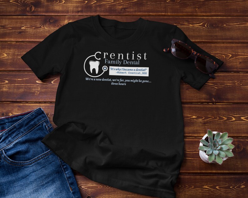 May include: Black t-shirt with a white graphic of a tooth and the text "Crentist Family Dental" with the quote "It's why I became a dentist! -Robert Crentist, 000" and the text "We're a new dentist, we're far, you might be gone... three hours".