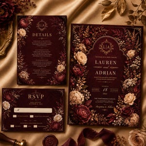 May include: A wedding invitation suite in deep burgundy featuring gold floral illustrations and ornate borders. The set includes a main invitation for Lauren and Adrian, a details card, and an RSVP card with text fields for guest names and meal choices.