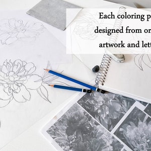 May include: A close-up of a drawing of a peony flower on white paper. Two pencils are lying on the paper. The text "Each colouring page is designed from original artwork and lettering" is visible in the background.