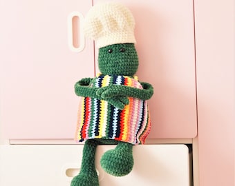 Muñeco amigurumi de chef en miniatura tejido a crochet: delantal, gorro y peluche suave.