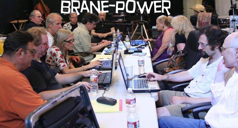May include: A group of people are sitting at a table working on laptops. The table is covered in a white tablecloth and there are several water bottles on the table. The text "Brane-Power" is visible in the background.