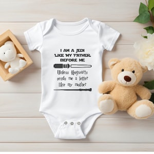 Puede incluir: Un body blanco para bebé con un gráfico negro que dice "Soy un Jedi como mi padre antes que yo. A menos que Hogwarts me envíe una carta como mi madre."