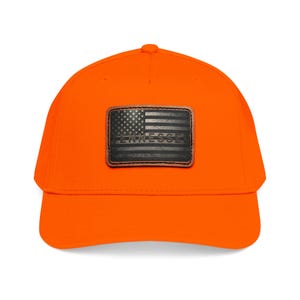May include: A bright orange baseball cap featuring a rectangular leather patch on the front. The patch displays a distressed American flag design in black and grey tones with the word TENNESSEE embossed horizontally across the center of the flag.