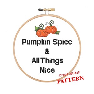 Könnte beinhalten: Kreuzstichmuster mit zwei orangefarbenen Kürbissen mit grünen Stielen und Blättern. Der Text lautet "Pumpkin Spice & All Things Nice" mit den Worten "Cross Stitch PATTERN" in Rot darunter.
